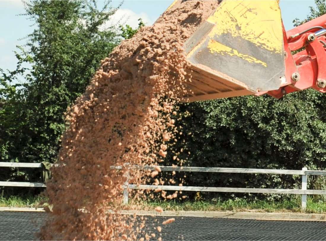 Bagger lässt Sand aus der Schaufel fallen